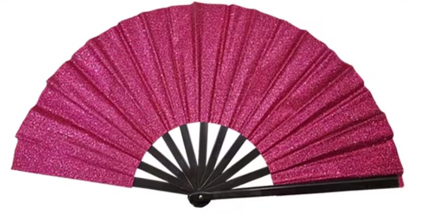 Fashionable and Shiny Foldable Hand Fan Add a touch of sparkling flair to your festival, concert, or warm-weather outfits with this trendy glittery foldable hand fan. Merging high-fashion aesthetic with on-the-go cooling functionality, this accessory features a radiant, light-catching fabric canopy mounted on a durable folding frame. It snaps open with a dramatic, fluid motion, providing an instant breeze while acting as a bold, shining statement piece that complements streetwear, party wear, and rave attire. High-Gloss Glitter Canopy: Constructed with premium, reflective fabric that beautifully bounces light under stadium beams or direct sunlight, ensuring you stand out in any crowd. Fluid Snap-Open Action: Built on a lightweight, reinforced framing structure that collapses compactly into pockets or bags and opens smoothly with a satisfying, theatrical flick of the wrist. Versatile Event Accessory: Functions as an eye-catching fashion statement and an essential cooling tool for hot summer festivals, dance floors, outdoor parties, or costume themes.